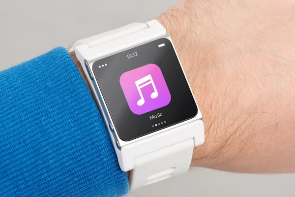 Закрыть белые умные часы с иконкой музыкального приложения на экране — стоковое фото
