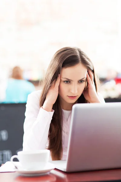 Gefrustreerd vrouw die op haar laptop werkt — Stockfoto