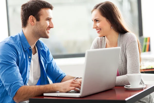 Pareja joven usando portátil — Foto de Stock