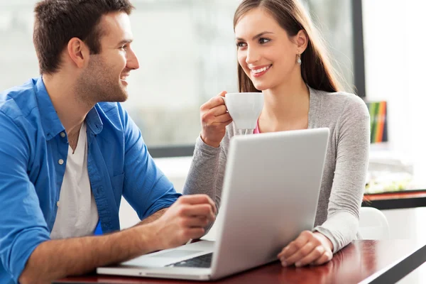 Pareja joven usando portátil — Foto de Stock