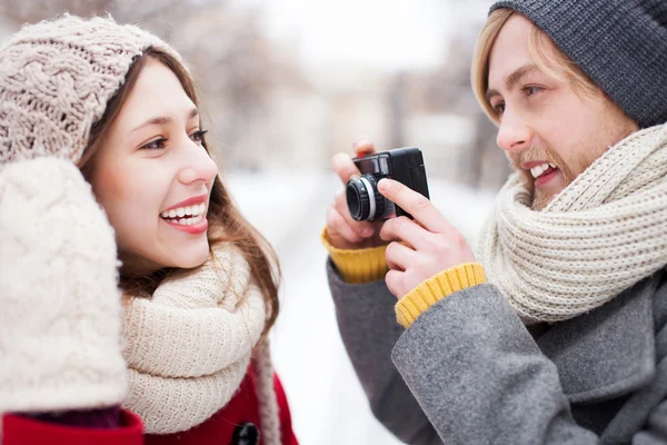 Young man taking photo of woman in winter — Stock Photo, Image