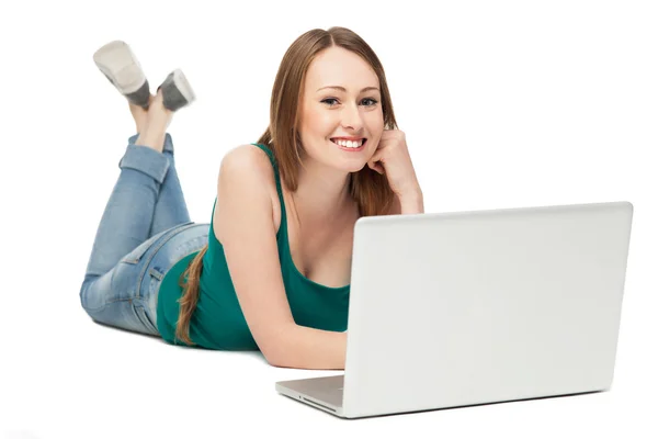 Mujer joven acostada y usando laptop — Foto de Stock