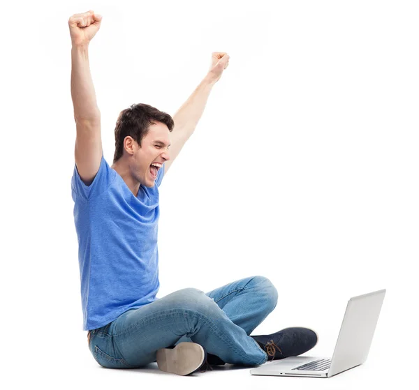 Podekscytowany młody człowiek korzysta z laptopa — Zdjęcie stockowe