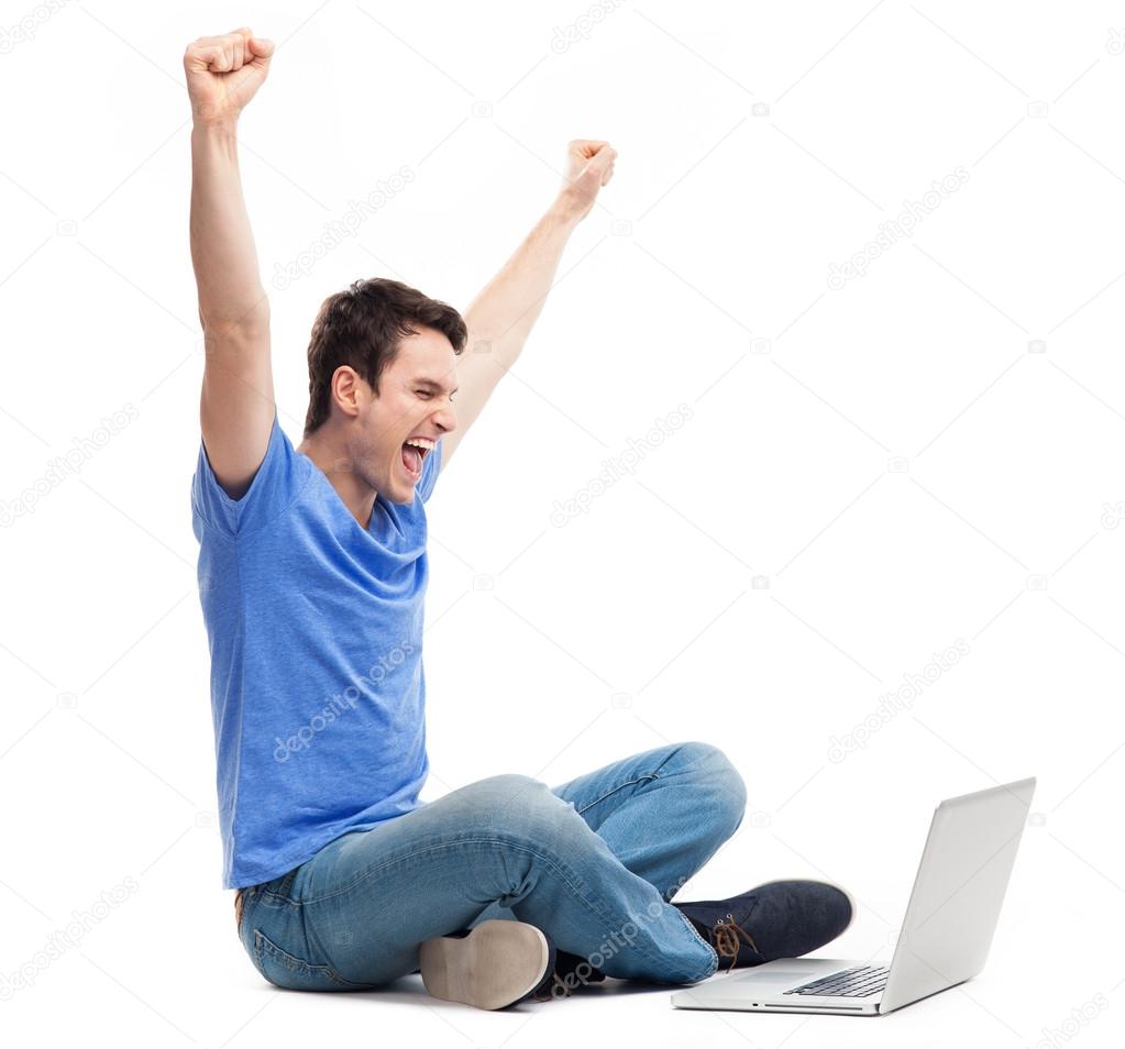 Excited young man using laptop