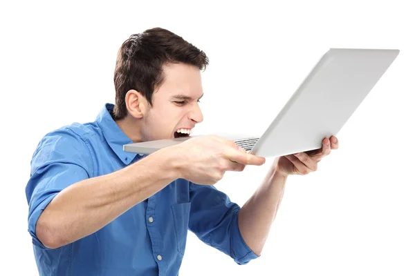 Άνθρωπος δαγκώνει ένα φορητό υπολογιστή στην απογοήτευση — Φωτογραφία Αρχείου