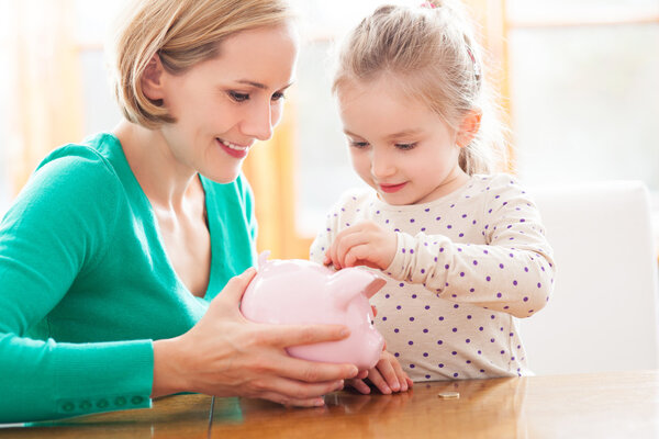 Mother and daughter with piggy bank