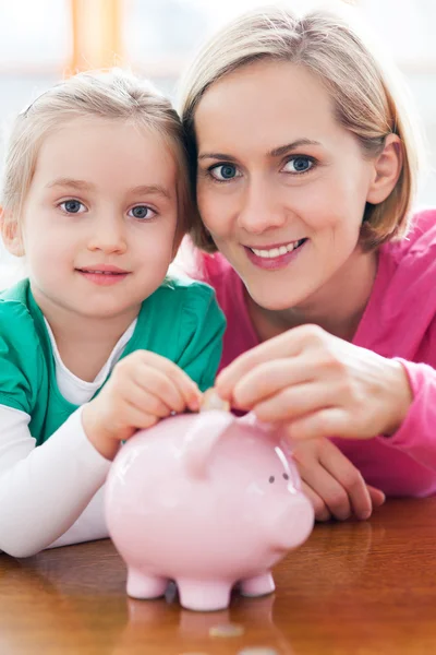 Mother and daughter with piggy bank Stock Photo