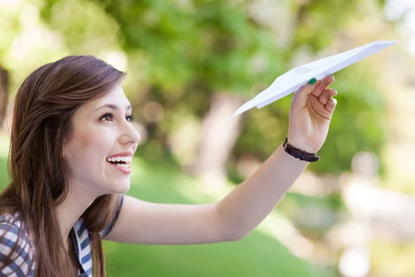 Jovem mulher jogando avião de papel — Fotografia de Stock