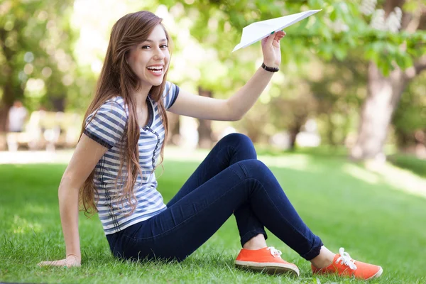 Mujer joven lanzando avión de papel — Foto de Stock