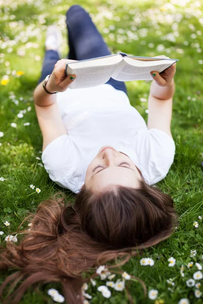 Jovem mulher ler livro ao ar livre — Fotografia de Stock