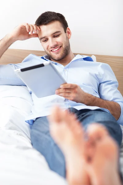 Mann entspannt sich mit digitalem Tablet — Stockfoto