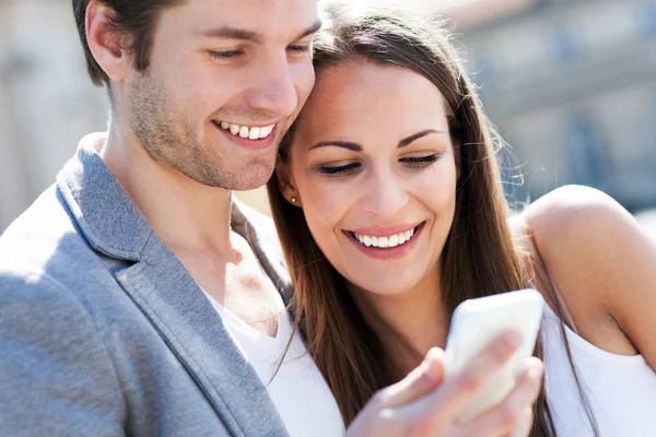 Χαμογελώντας ζευγάρι με κινητό τηλέφωνο — Φωτογραφία Αρχείου