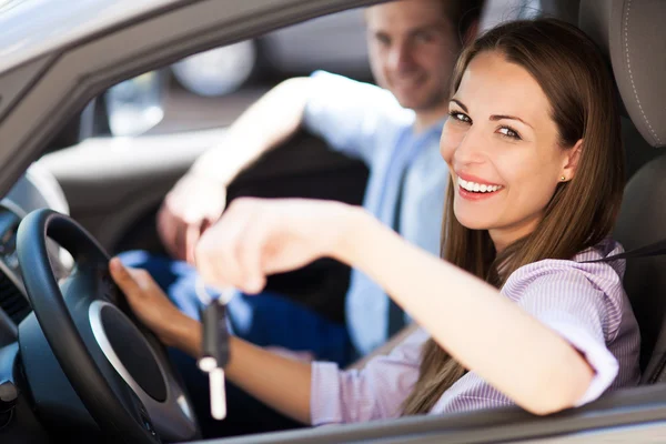 Junge Frau zeigt Autoschlüssel — Stockfoto