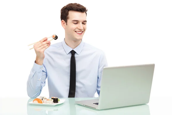 Man med laptop äta sushi — Stockfoto