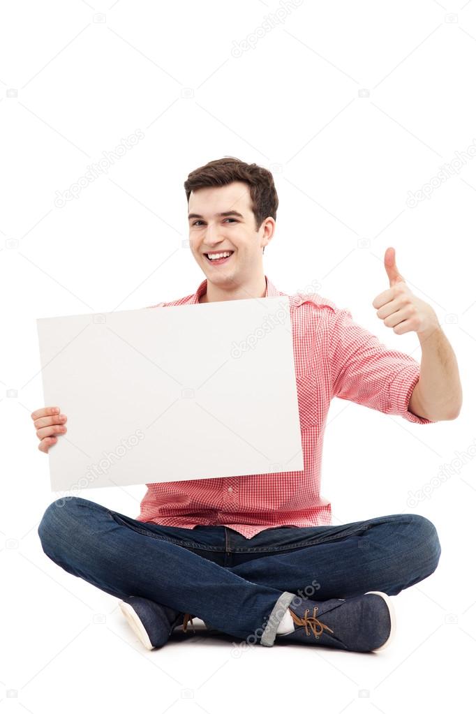 Young man holding blank poster