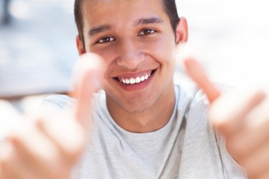 Genç adam başparmağını kaldırıyor.