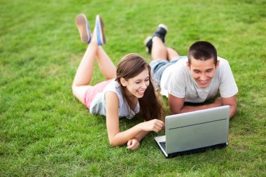 genç bir çift ile laptop çim üzerinde yalan