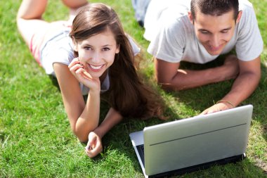 genç bir çift ile laptop çim üzerinde yalan