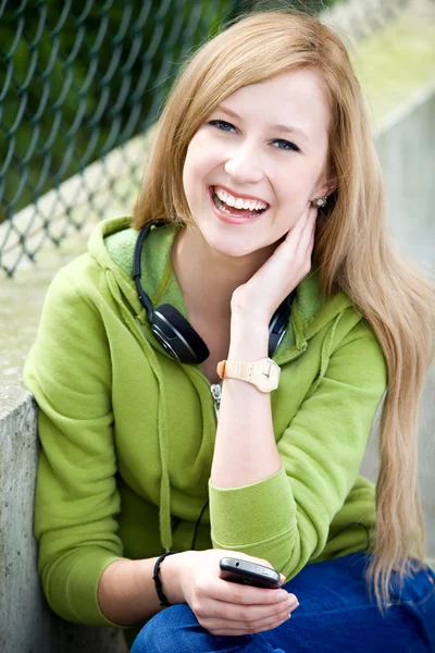 Teenage girl sitting outdoors — Stock Photo, Image