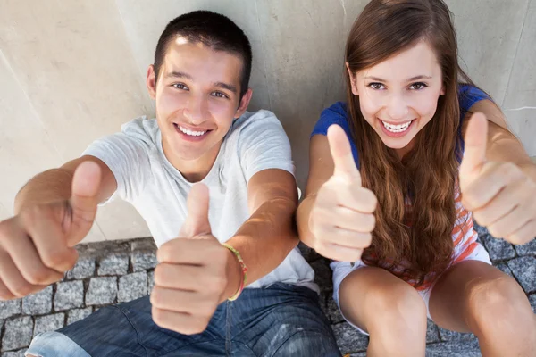 Adolescente coppia con i pollici in su — Foto Stock