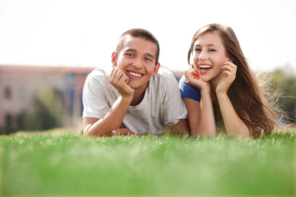 Jeune couple couché sur l'herbe — Photo