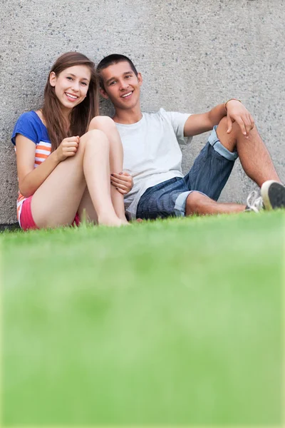 Jong koppel zittend op het gras — Stockfoto