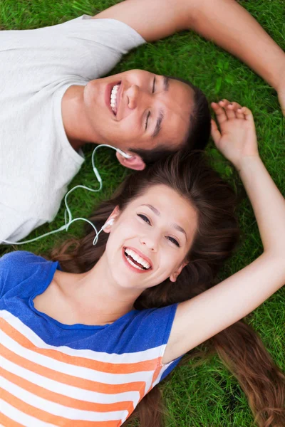 Молодая пара лежит на траве — стоковое фото