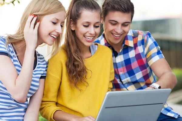 Friends looking at laptop together — Stock Photo, Image