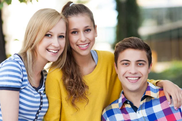 Drie jonge vrienden permanent samen — Stockfoto