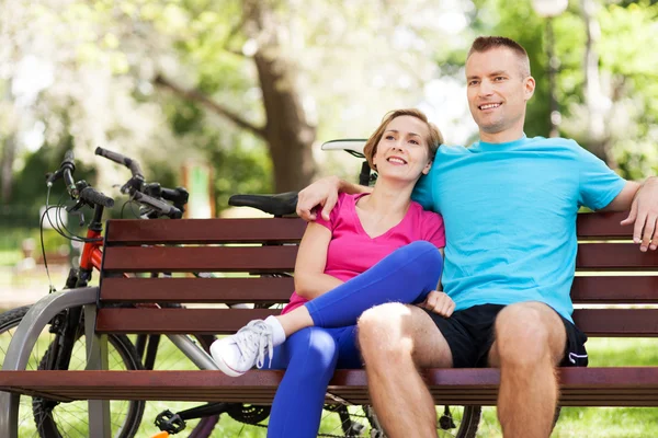 Pareja con sus bicicletas en un parque — Foto de Stock