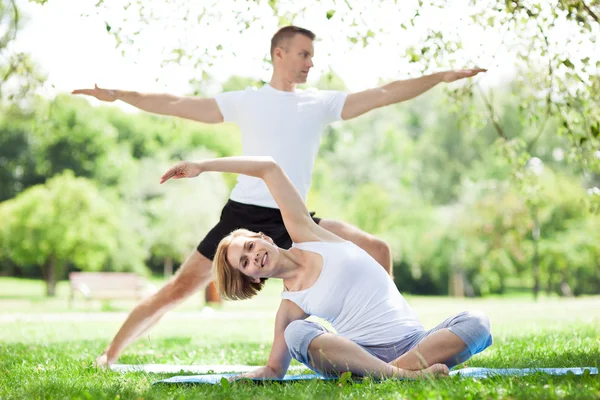 Casal praticando ioga no parque — Fotografia de Stock