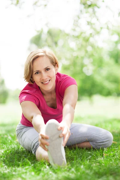 Woman stretching in a park — Stock Photo, Image