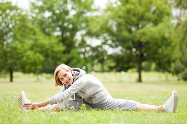 Donna che si estende in un parco — Foto Stock