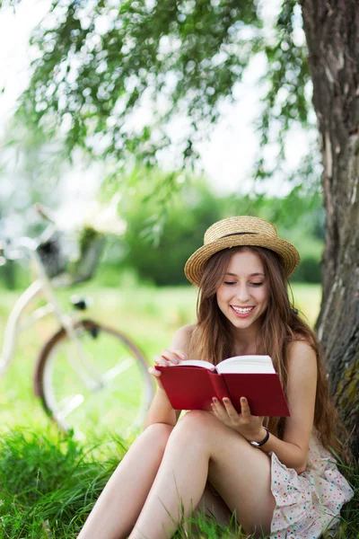 Kvinna läser en bok under trädet — Stockfoto