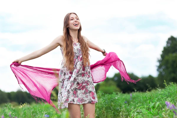 Woman in meadow holding scarf — Stock Photo, Image