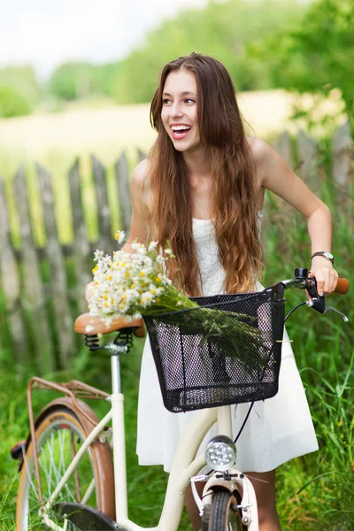 木製フェンスでバイクを持つ女性 — ストック写真