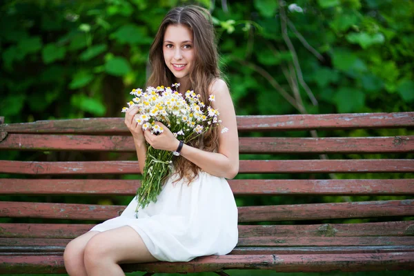 Žena sedí na lavičce v parku — Stock fotografie