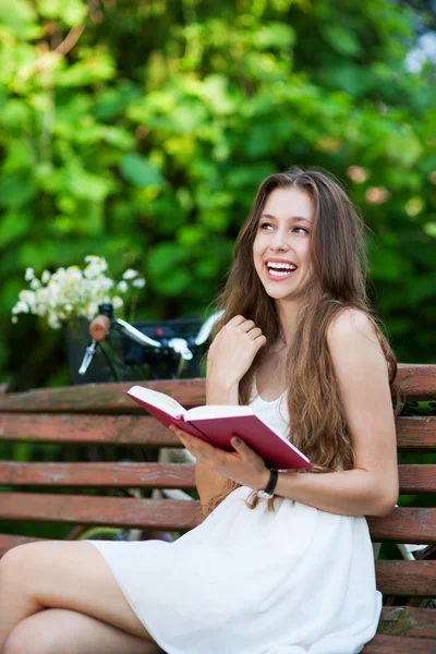 Mulher leitura livro no banco do parque — Fotografia de Stock