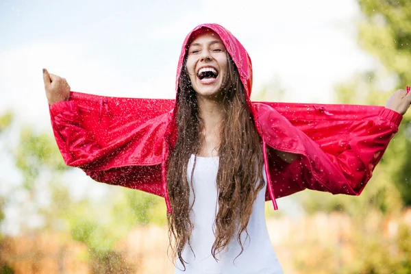 Mujer en impermeable disfrutando de la lluvia — Foto de Stock