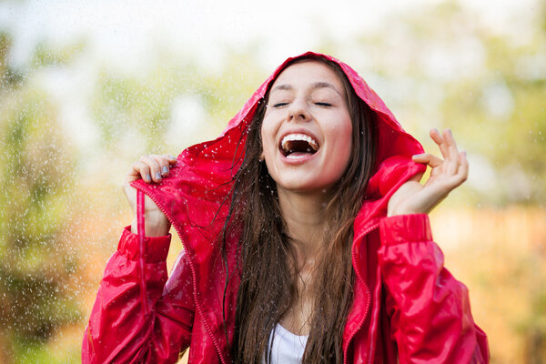 Woman in raincoat enjoying the rain