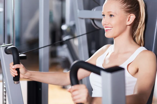 Jeune femme travaillant à la salle de gym — Photo