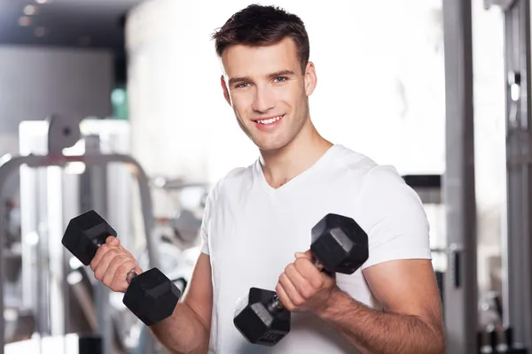 Giovane uomo che lavora in palestra — Foto Stock