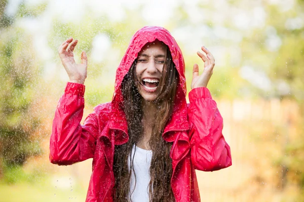 Woman in raincoat enjoying the rain Stock Picture