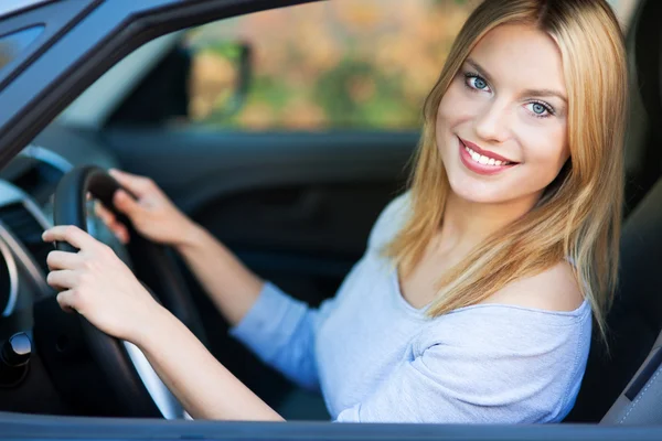 Femme souriante assise dans la voiture — Photo