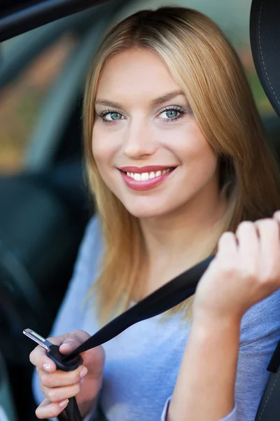 Femme souriante assise dans la voiture — Photo