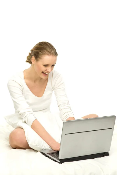 Kvinna som använder laptop i sängen — Stockfoto