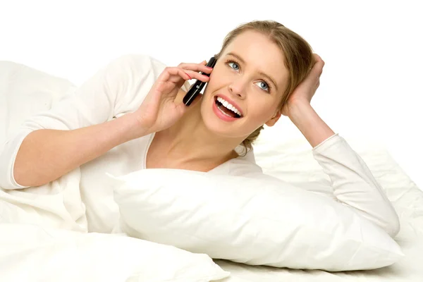 Mujer joven acostada en la cama con teléfono —  Fotos de Stock