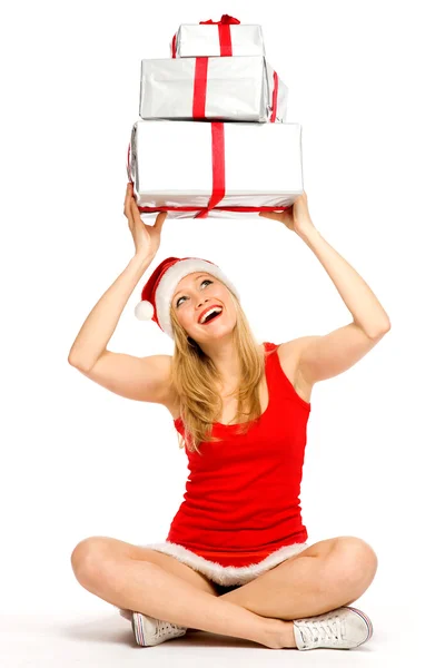 Mujer en Santa sombrero sosteniendo regalos Imágenes de stock libres de derechos