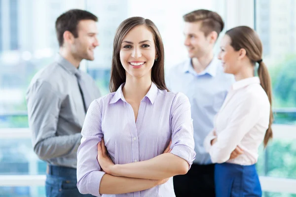 Geschäftsfrau mit Mitarbeitern im Hintergrund — Stockfoto