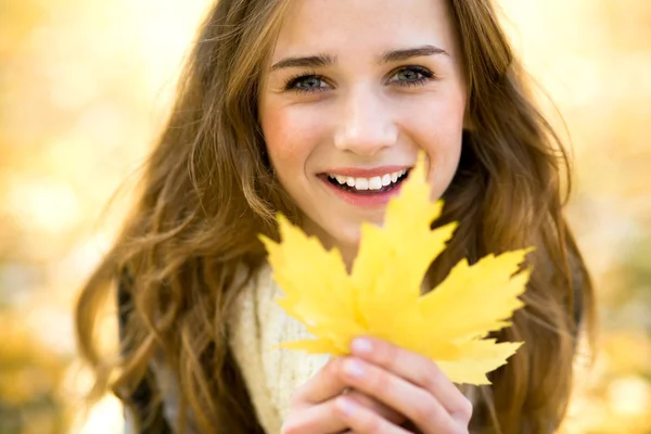 Frau hält Herbstblatt in der Hand — Stockfoto